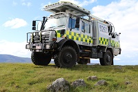 Image of a unimog vehicle with green an yellow chequered stripe