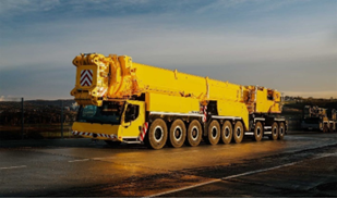 Yellow crane with nine axles on the road