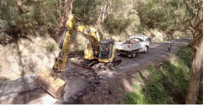 Digger excavating on a road