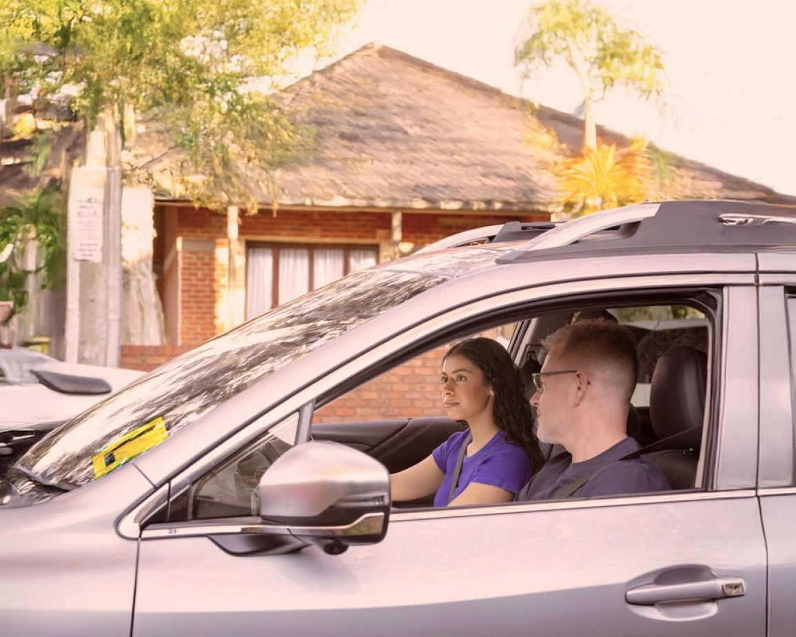 Car with two people inside. Find out how to take the Learner Permit Test online.