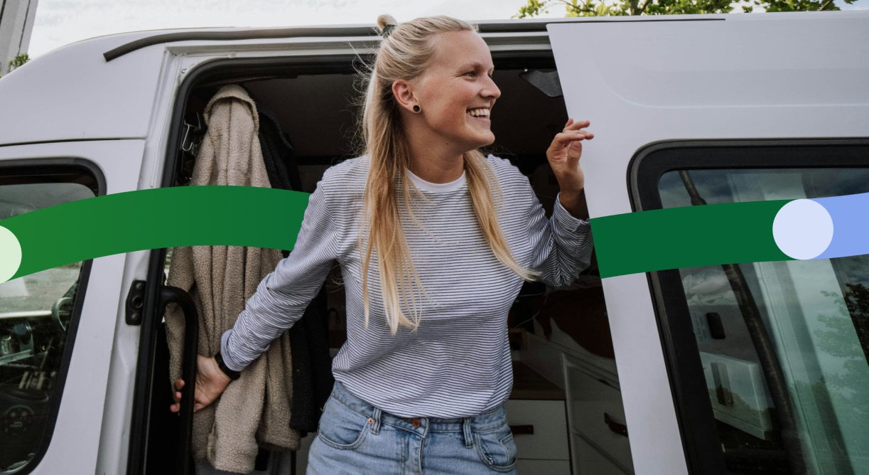 Woman steps out of a white van, holding on to the door while looking to the side.