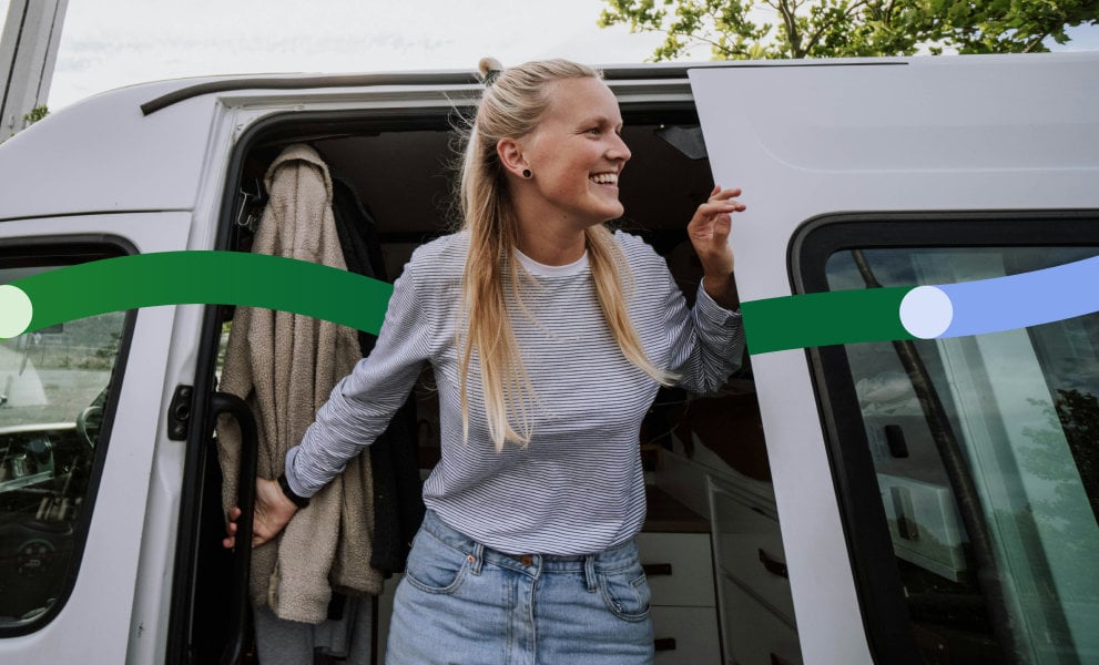 Woman steps out of a white van, holding on to the door while looking to the side.