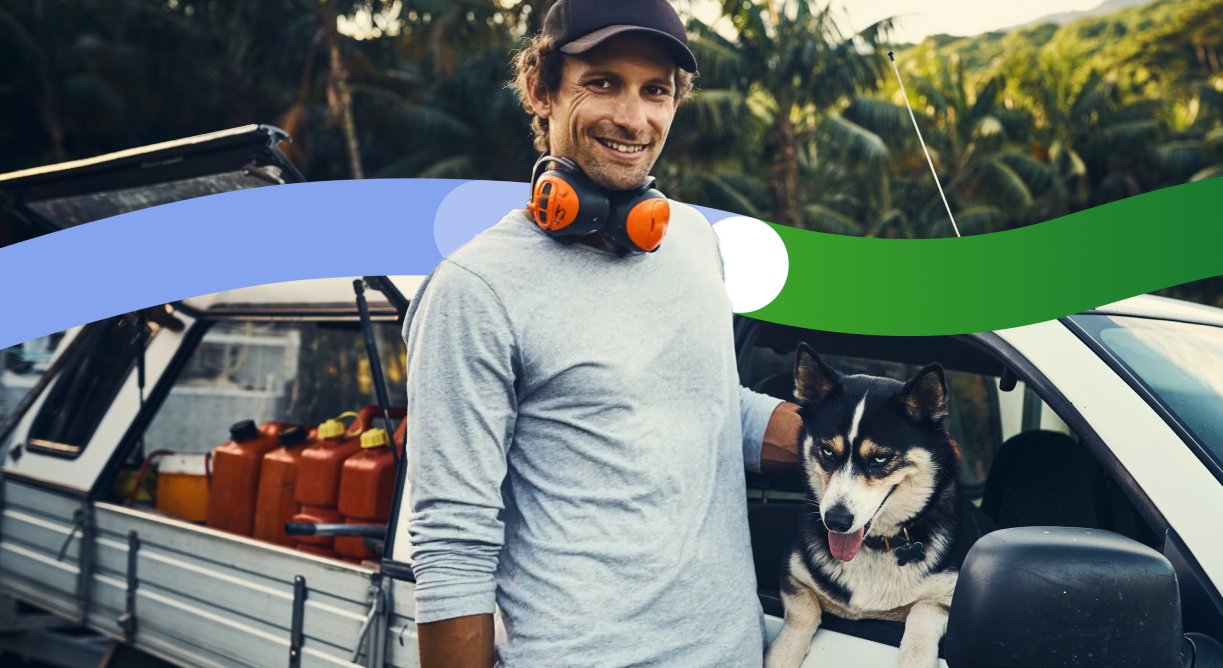 Tradie wearing headphones stands outside his work vehicle.