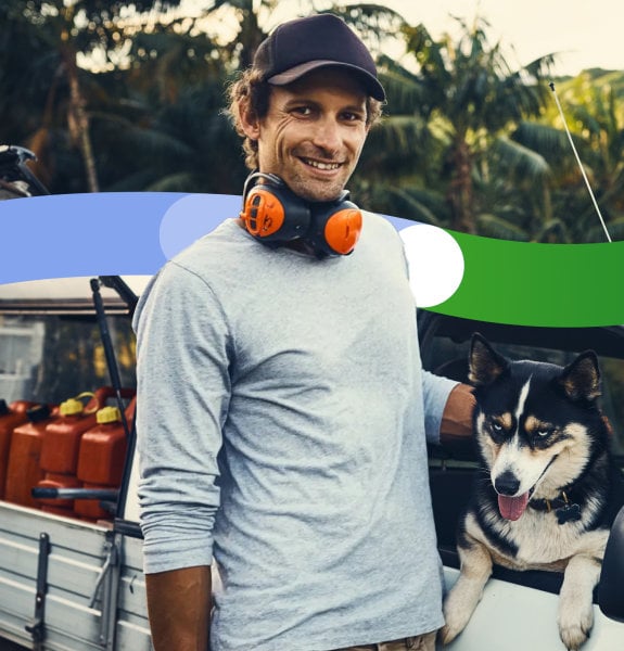 Tradie wearing headphones stands outside his work vehicle.