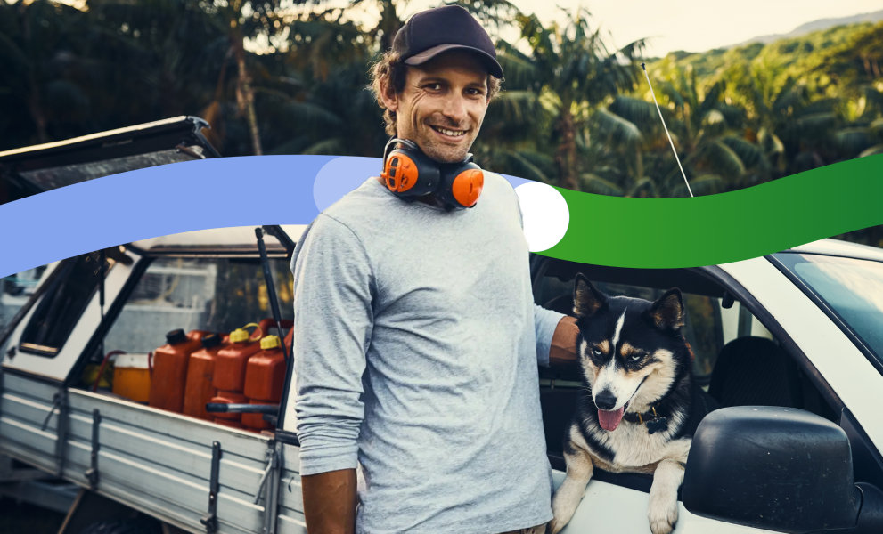 Tradie wearing headphones stands outside his work vehicle.